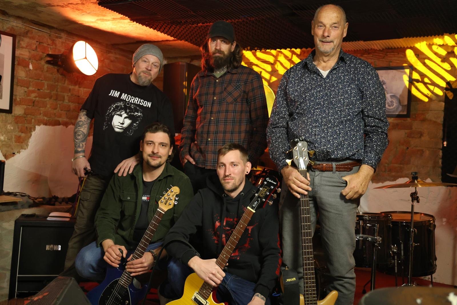 Gruppenfoto der Band mit Gitarren im Proberaum